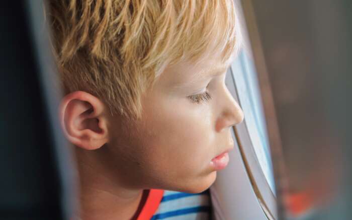 Ein Kind schaut aus dem Flugzeugfenster