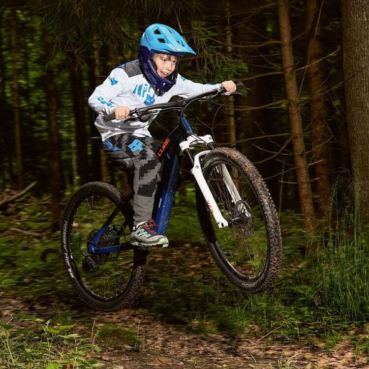 Junge fährt auf einem Mountainbike im Wald