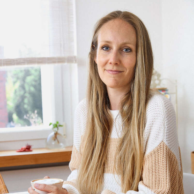 Frau Gähwiler sitzt am Tisch und hält eine Kaffeetasse in der Hand