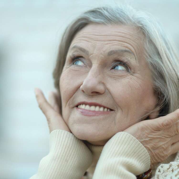 Eine ältere Frau lächelt glücklich