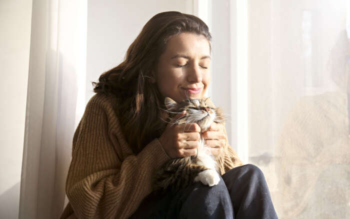 Eine Frau kuschelt glücklich ihre Katze