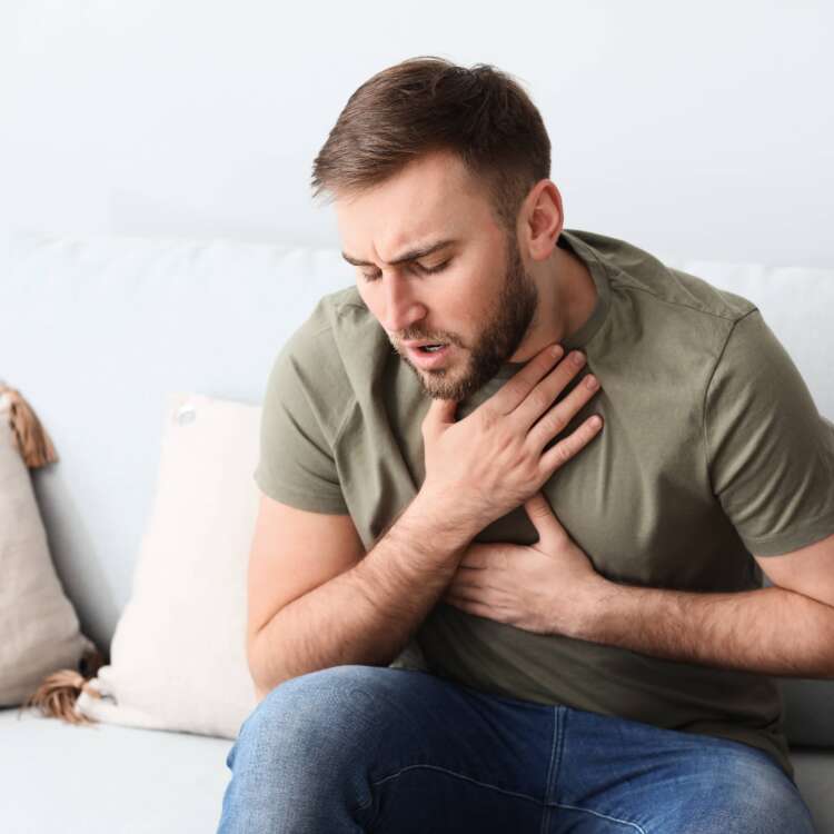 Wegen einer Allergie kann ein Mann schlecht atmen und hebt sich den Hals und die Brust